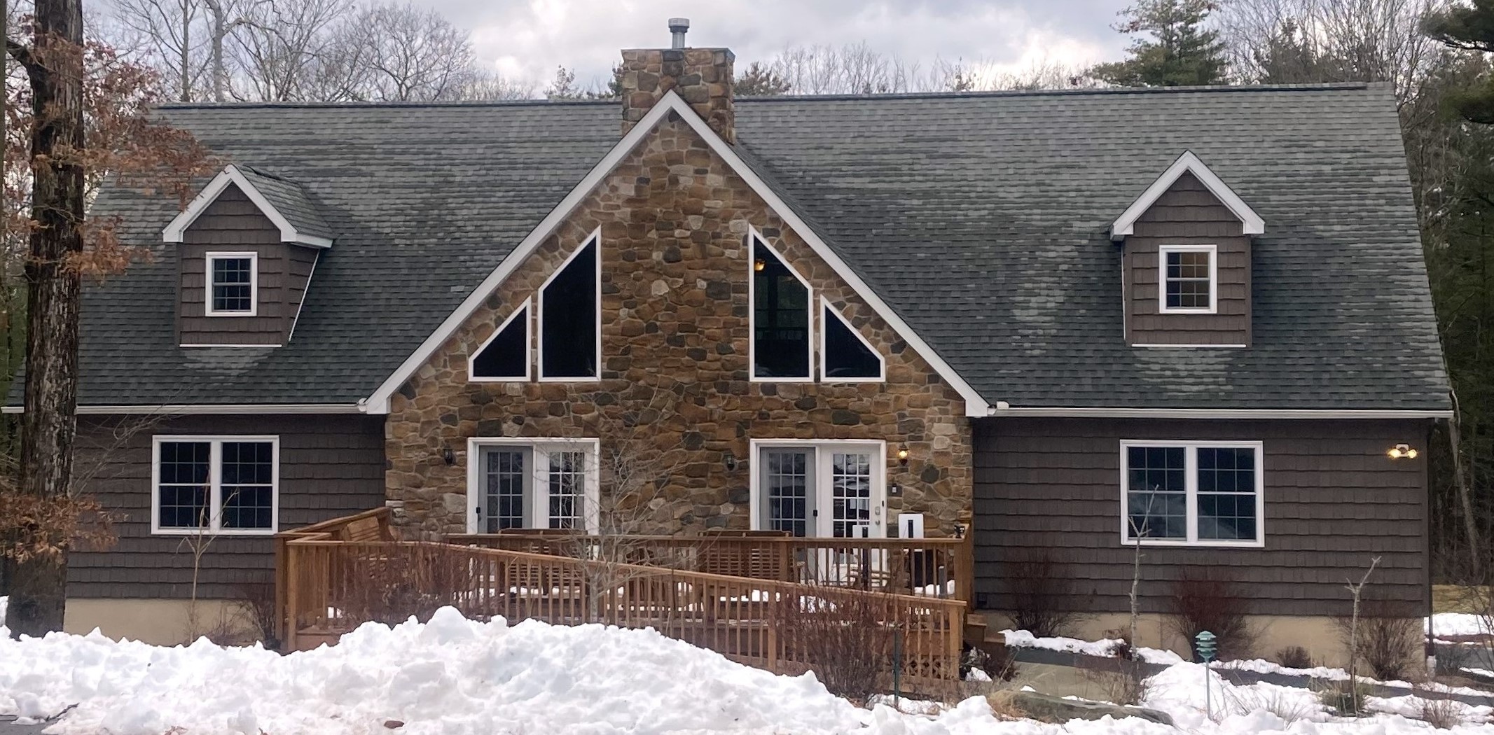 Stone front home in snow.